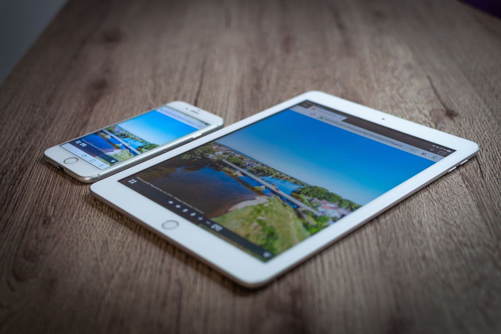 Tablet und Smartphone liegen auf einem Holztisch
